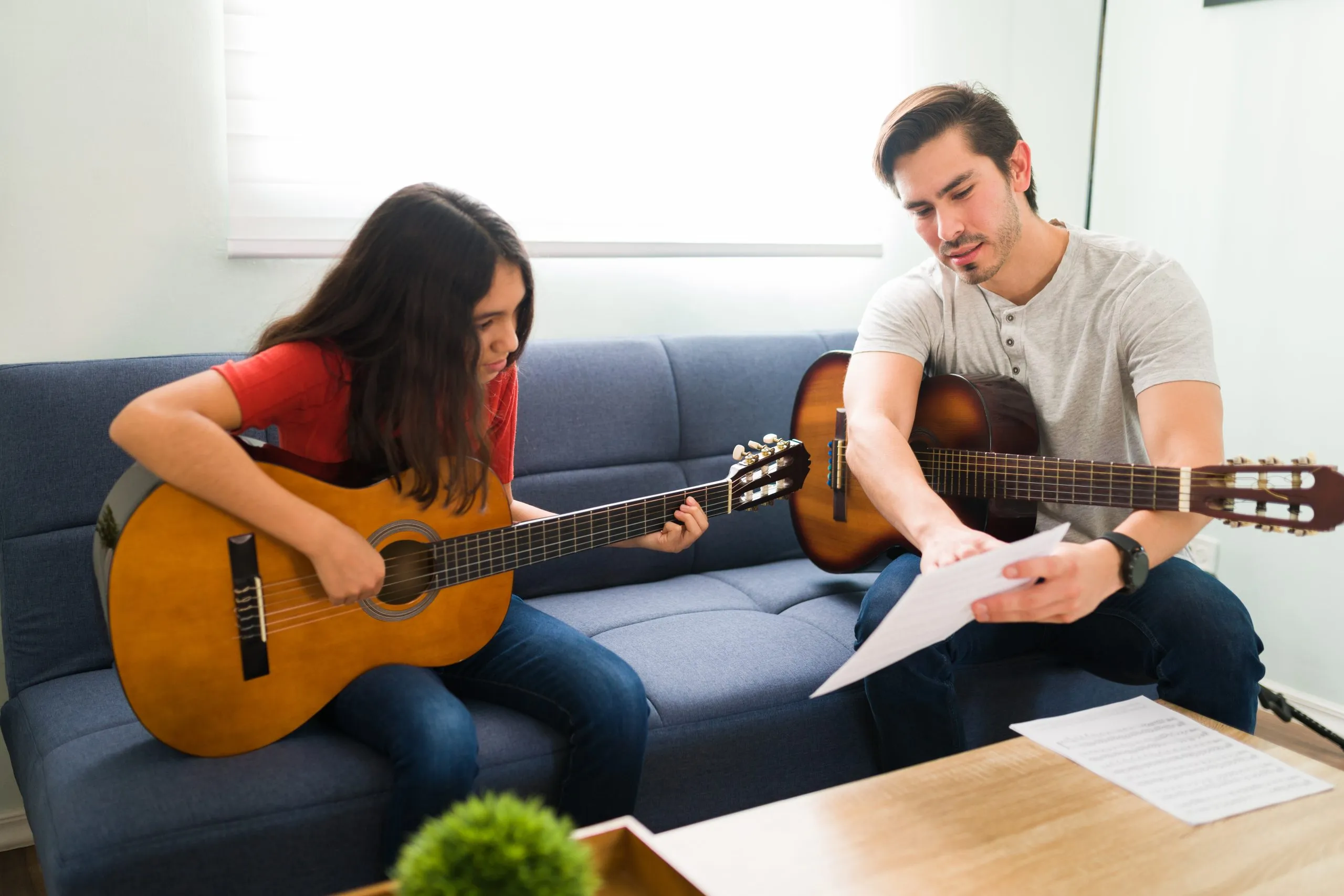 A music teacher and a child reading sheet music together
